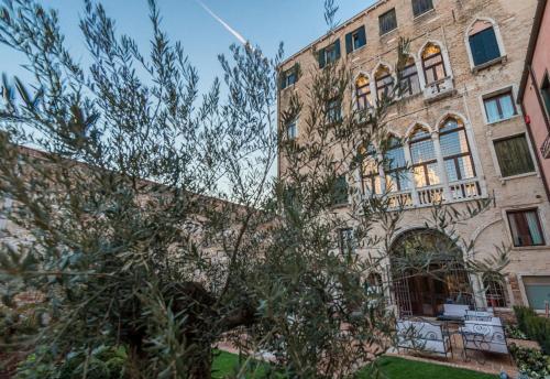a building with a tree in front of it at Hotel Nani Mocenigo Palace in Venice