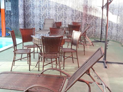 a group of chairs and tables and a pool at Pousada Sol Nascente in Olímpia