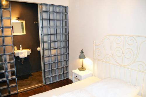 a bedroom with a bed and a bathroom with a mirror at St. Pauli Lodge in Hamburg