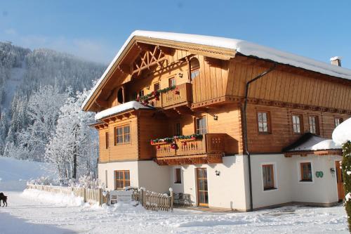 une maison en bois avec un balcon dans la neige dans l'établissement Haus Annabelle, à Wagrain