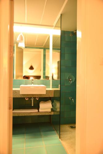 ein Bad mit einem Waschbecken und einem Spiegel in der Unterkunft The Port Hotel in Visakhapatnam