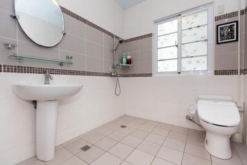 a bathroom with a toilet and a sink and a mirror at White Cotton Candy Homestay in Hualien City