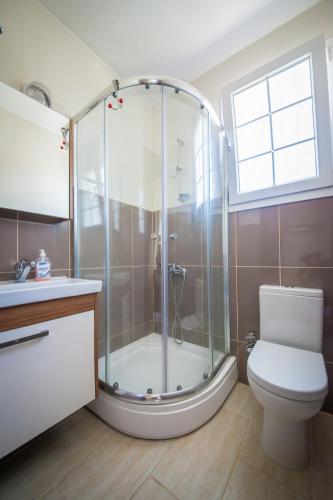 a bathroom with a shower and a toilet and a window at Villa Daria in Kyrenia