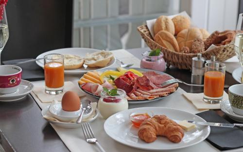 a table with plates of breakfast food on it at Hotel die Hindenburg in Saalfelden am Steinernen Meer