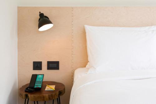 a bedroom with a bed and a table with a phone on it at amba Taipei Zhongshan in Taipei