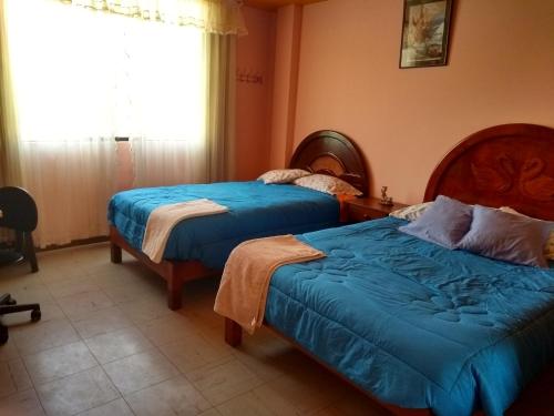 a bedroom with two beds and a window at Ramirez House in Arequipa