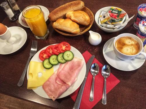 una mesa con un plato de comida con carne y verduras en Old House, en Hradec nad Moravicí