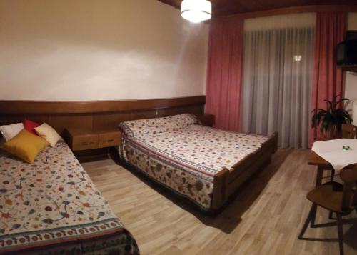a hotel room with two beds and a table at Haus Christof in Ledenitzen