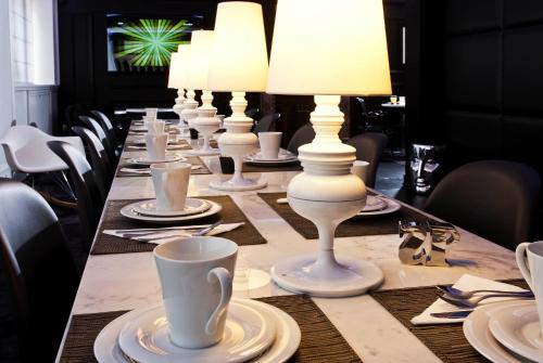 a white table topped with white plates and chairs at Hotel Icône in Paris