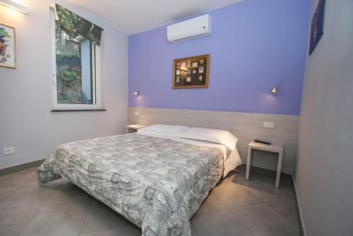 1 dormitorio con cama y pared púrpura en Le Coste by Arbaspàa en Manarola