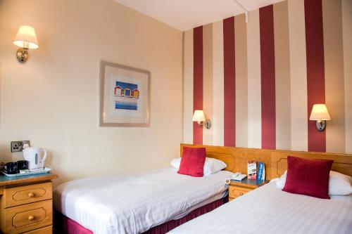 two beds in a hotel room with red and white stripes at Viking Hotel - Adults Only in Blackpool