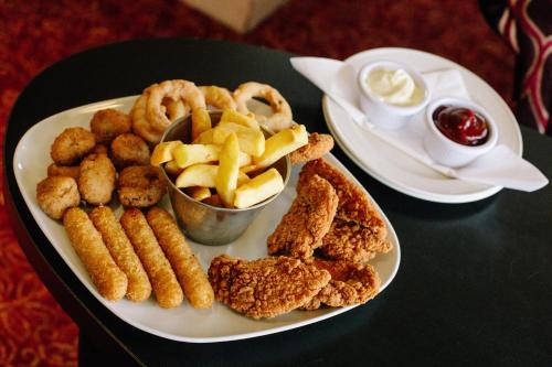 a plate of food with onion rings and onion rings at Viking Hotel - Adults Only in Blackpool