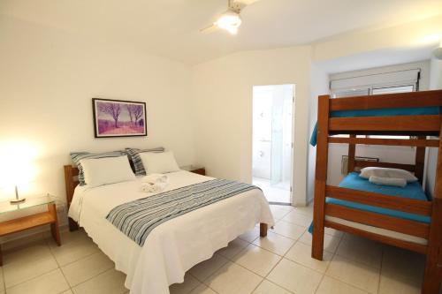 a bedroom with a bed and a chair in it at Suites em Juquei in Juquei