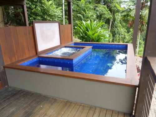 a hot tub on the deck of a house at Daintree Holiday Homes - La Vista in Cow Bay