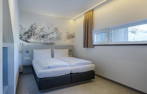Una cama pequeña en una habitación con ventana. en Riverside Residence Flachau, en Flachau