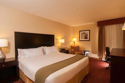 a hotel room with a large bed and a desk at Holiday Inn Express Vernon-Manchester, an IHG Hotel in Vernon