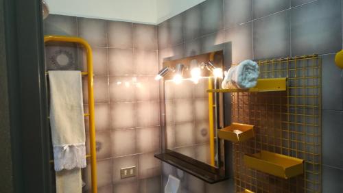 uma casa de banho com um chuveiro, um espelho e uma toalha em Alba Apartment em Laigueglia
