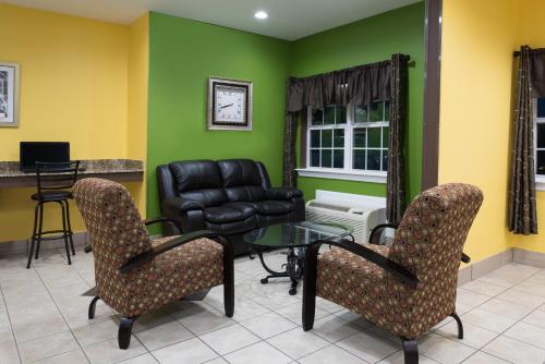 a waiting room with a chair and a table at Microtel Inn by Wyndham Rogers in Rogers