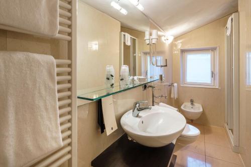 a bathroom with a sink and a toilet at Hotel Olimpia in Cortina dʼAmpezzo