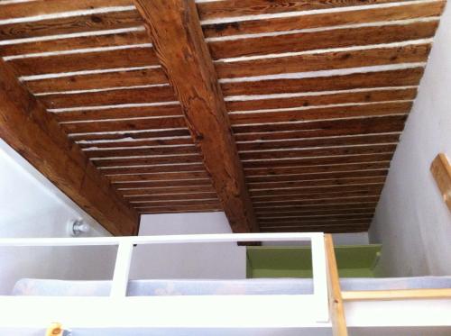 マルセイユにあるADORAMAAR- LES STUDIOSの木製の天井と二段ベッド付きのベッドルーム1室が備わります。