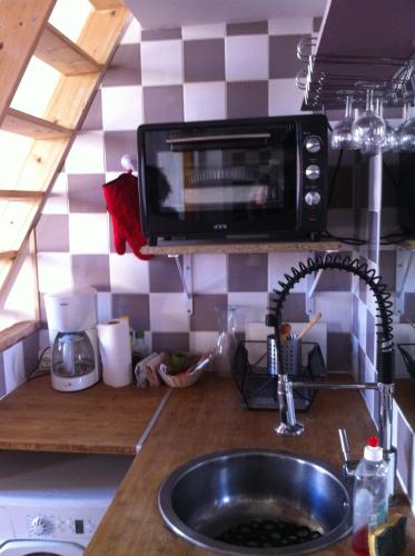 une cuisine avec un évier et un micro-ondes dans l'établissement ADORAMAAR- LES STUDIOS, à Marseille