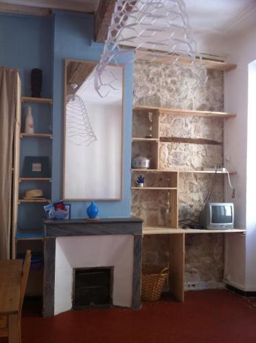 un salon avec une cheminée et un miroir dans l'établissement ADORAMAAR- LES STUDIOS, à Marseille