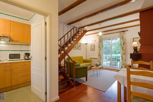 a kitchen and living room with a spiral staircase at Quinta Santo Antonio Da Serra in Santa Cruz