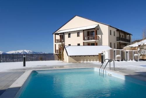 ein Haus mit Pool im Schnee in der Unterkunft Résidence Odalys Mille Soleils in Font-Romeu