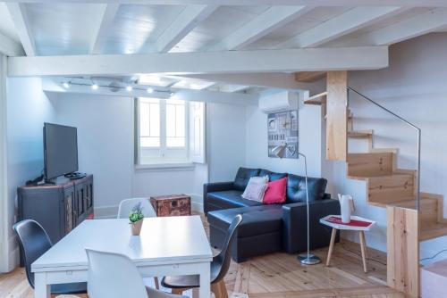 a living room with a blue couch and stairs at FeelCoimbra Castelo Boutique Apartments in Coimbra