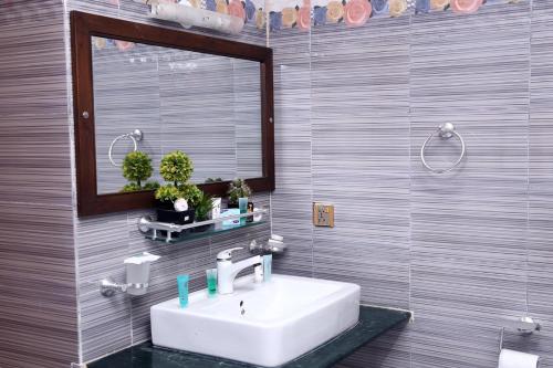卡拉奇的住宿－Hilton Bayview lnn，一间带水槽和镜子的浴室