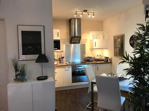 une cuisine avec des armoires blanches et une table avec des chaises dans l'établissement Villa Lina, à Bandol