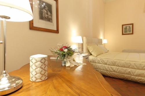a living room with a bed and a table with flowers on it at Dimora Bandinelli in Florence