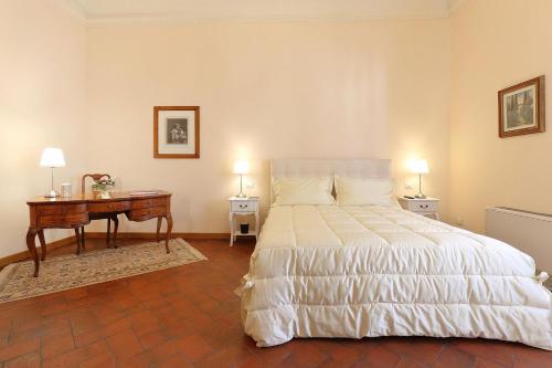 a bedroom with a bed and a desk with two lamps at Dimora Bandinelli in Florence