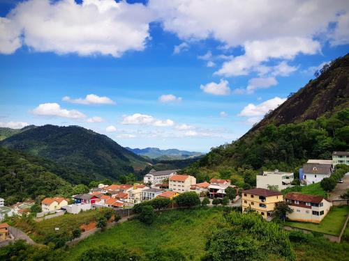 un villaggio su una collina con montagne sullo sfondo di Cobertura das Montanhas a Domingos Martins