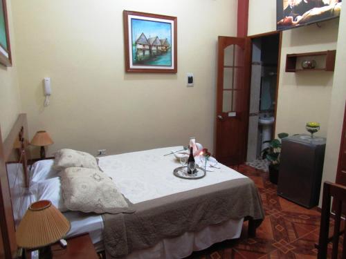 a room with a bed with a table in it at Alojamiento El Cardenal in Iquitos