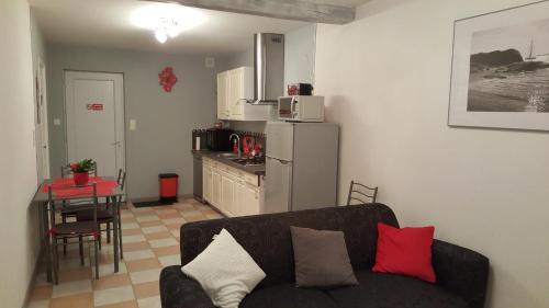 a living room with a couch and a kitchen at Gite Pourquoi Pas in Montégut-Lauragais