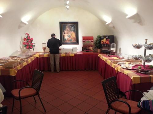 a man standing in the middle of a room with tables at Domus Sessoriana in Rome