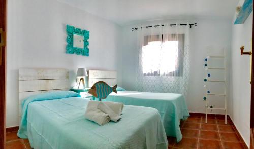 1 dormitorio con 2 camas y ventana en Villa Margarita, en Valle de Santa Inés