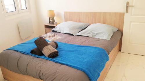 - un lit avec une couverture bleue et des oreillers dans l'établissement Le De Gaulle, à Antibes