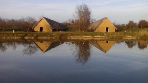 two barns reflected in the water of a lake at Jakuzzis,Szaunás,Kerkavendégház-Őrség-Csesztreg-Kerkaujfalu in Csesztreg