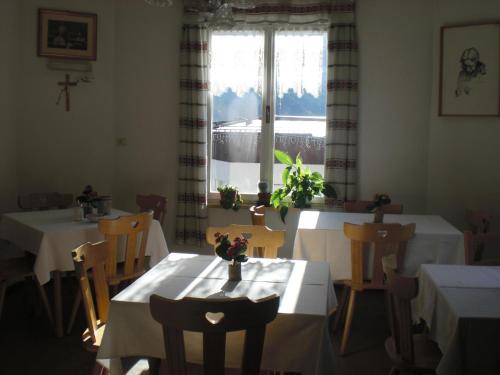 a dining room with two tables and a window at B&B Rosalpina in Vigo di Fassa