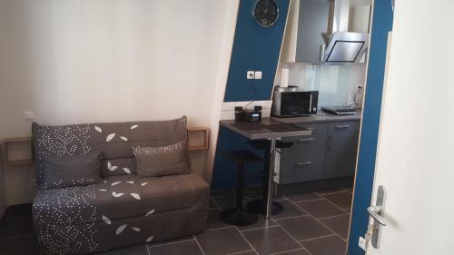 um quarto com um sofá, uma secretária e uma mesa em Les Mouettes em Le Tréport