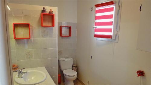 une salle de bain avec un lavabo et des toilettes et une fenêtre dans l'établissement Les Lavandins-Gite Vincent, à Saint-Rémy-de-Provence