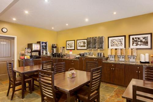 a restaurant with a table and chairs and a coffee shop at Ramada by Wyndham Cold Lake in Cold Lake
