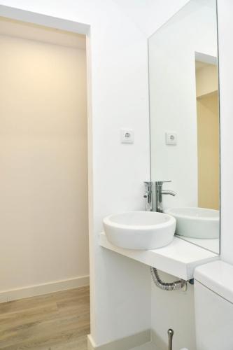 a white bathroom with a sink and a mirror at Encarnação Home in Lisbon