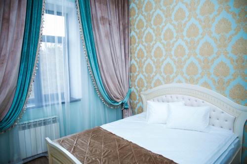 um quarto com uma cama branca e uma janela em Jasmine em Taraz