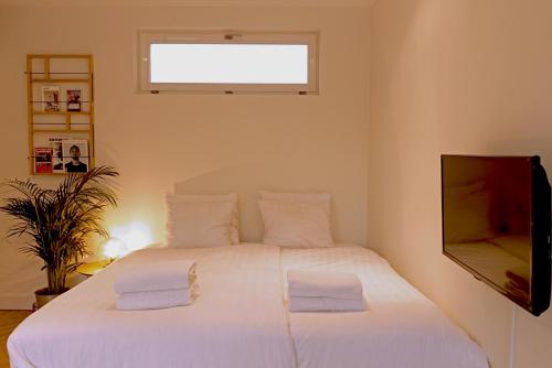 sypialnia z białym łóżkiem i telewizorem w obiekcie Da Costa Suite w Amsterdamie
