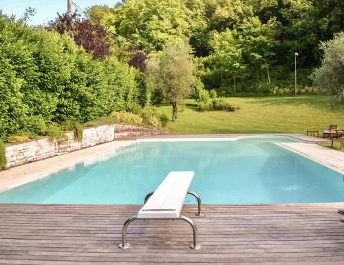 eine Bank auf einem Deck neben einem Pool in der Unterkunft Casale Bellaguardia in Fossombrone