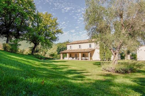 a house with a large yard with green grass at Casale Bellaguardia in Fossombrone