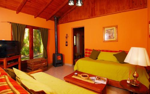 Una sala de estar con dos camas y un televisor. en Estancia Don Jose- GuenGuel, en Río Mayo